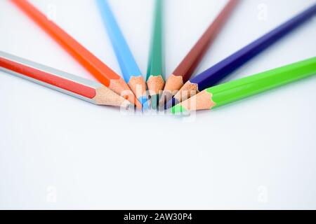 Top view of seven different colored pencil crayons arranged in a half circle pattern Stock Photo