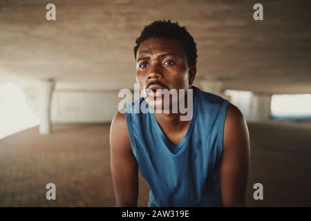 Portrait of a fit young male athlete feel fatigue taking a break after morning run Stock Photo