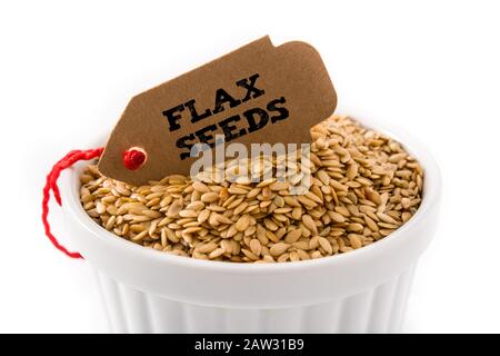 Golden flax seeds in white bowl isolated on white background Stock Photo