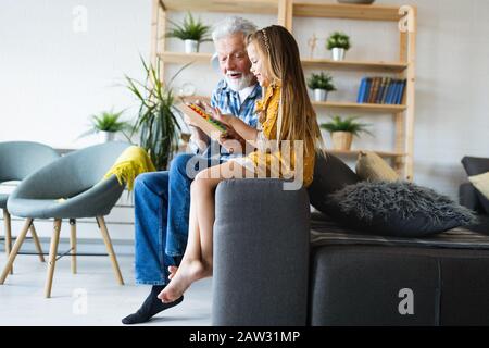 Grandfather and child playing together at home. Happiness, family, relathionship, learning concept. Stock Photo