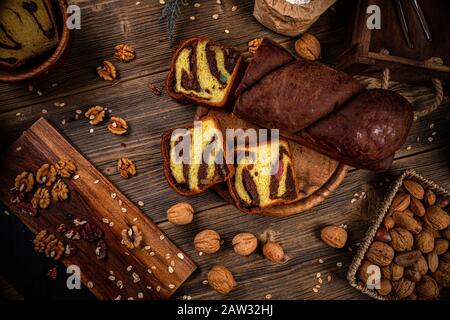 Tasty braided bun with walnuts and Turkish delight on a wooden background Stock Photo