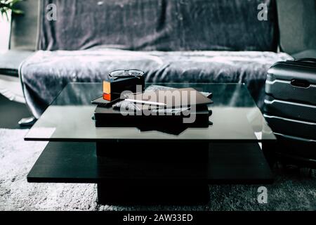 iPad and glasses on a shiny coffee table with sofa Stock Photo