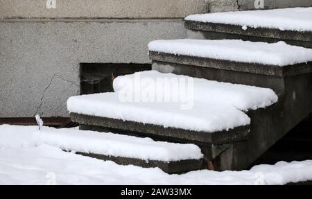 Dangerous uncleaned stairs in front the building, slippery stairs. Icy sidewalk. Stock Photo