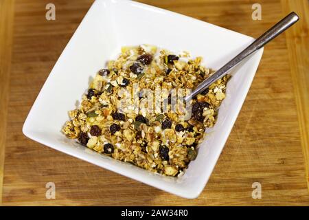 Bowl of homemade granola made with raisins, seeds, and nuts. It is low in sugar and fat and both vegetarian- and vegan-friendly. Stock Photo