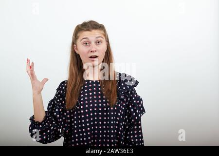 beautiful girl in a black dress with white circles shocked by the situation Stock Photo