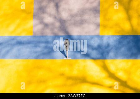 Yellow blue wall with old lantern hangs in the center. Stock Photo