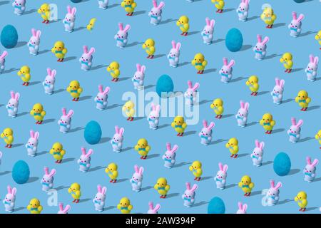Trendy Easter pattern made of rabbits hares, chicken and egg woolen toys on blue background in minimal style. Easter concept in minimal style. Stock Photo