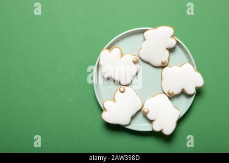 Easter cookies on a plate on a green background. View from above. Place for text. Stock Photo