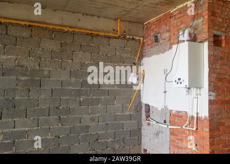 The room in a newly built brick building with a gas water heater and communications Stock Photo
