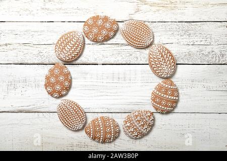 Easter cookies on a white wooden background. Place for text. Easter eggs. In the shape of a frame. Stock Photo