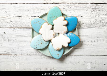 Easter cookies on a plate on a wooden background. Easter eggs. Easter bunnies. Place for text. Stock Photo