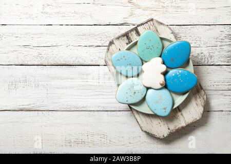 Easter cookies on a plate on a wooden background. Easter eggs. Easter bunnies. Place for text. Stock Photo