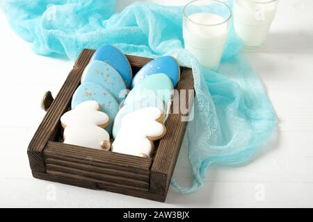 Easter cookies in a drawer. Glass of milk. Easter eggs. Easter bunnies. Stock Photo