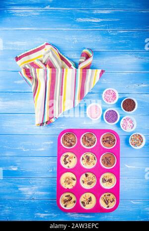Pouring cake into silicone mold on blue wooden rustic background. Stock Photo