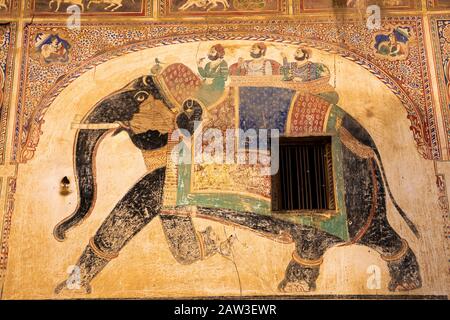 India, Rajasthan, Shekhawati, Mandawa, painted elephant with people on howdah on wall of decorated haveli being restored as heritage hotel Stock Photo