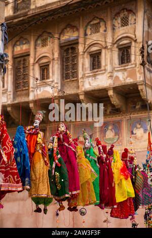 India, Rajasthan, Shekhawati, Mandawa, tourist souvenir puppets for sale outside decorated haveli being restored as heritage hotel Stock Photo
