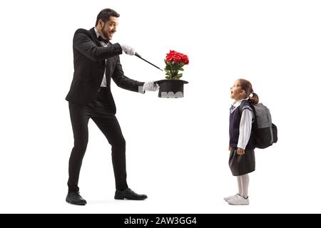 Full length shot of a magician making a magic trick with roses and an excited schoolgirl watching isolated on white background Stock Photo