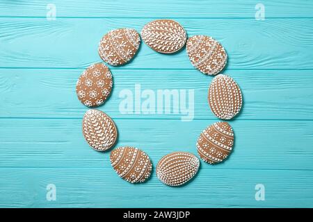 Easter cookies in a plate on a blue background. Easter eggs. In the shape of a frame. Place for text. View from above. Stock Photo