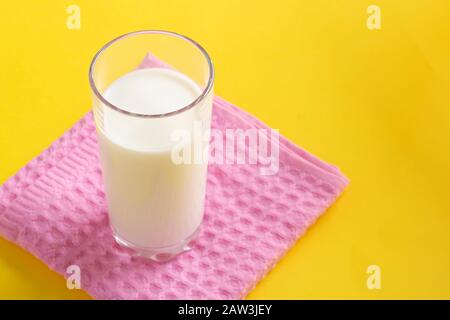 Fresh homemade ayran, lassi in glass over pink towel, copy space food. Probiotic cold fermented dairy drink. Stock Photo
