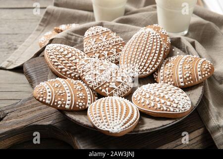 beautiful easter cookies on a plate, a glass of milk. On old wooden background Stock Photo