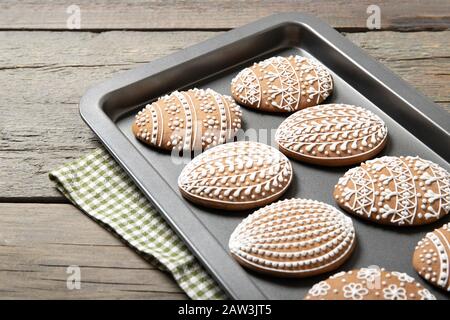 Easter cookies on a baking sheet on an old wooden background. Easter egg. Stock Photo