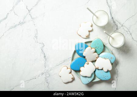 Easter cookies in a plate on a concrete background. Glass of milk. Easter eggs. Easter bunnies. Stock Photo