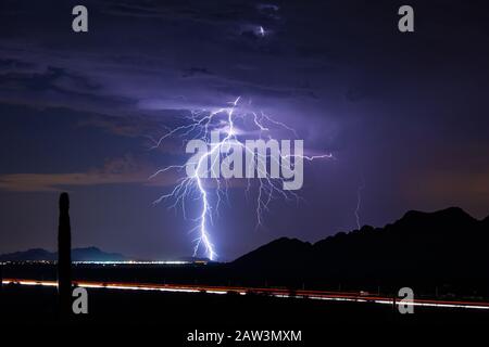 A bright lightning bolt strikes from a monsoon storm over Eloy, Arizona Stock Photo