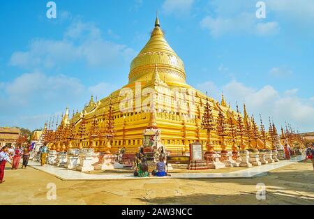 BAGAN, MYANMAR - FEBRUARY 25, 2018: Panorama of historical Shwezigon Pagoda with giant golden stupa, decorated with relief patterns, sculptures and be Stock Photo
