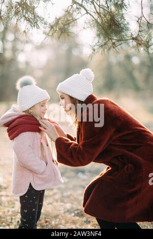 Mother and daughter are on the stroll in the pine forest. Stock Photo