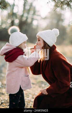 Mother and daughter play and have fun while walking in the forest. Stock Photo