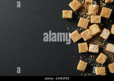 Brown sugar cubes on black background, top view Stock Photo