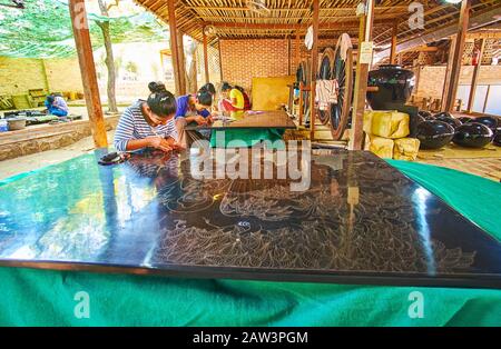 BAGAN, MYANMAR - FEBRUARY 25, 2018: Authentic lacquerware workshop with numerous workers, creating pictures, tableware and souvenirs in unique techniq Stock Photo