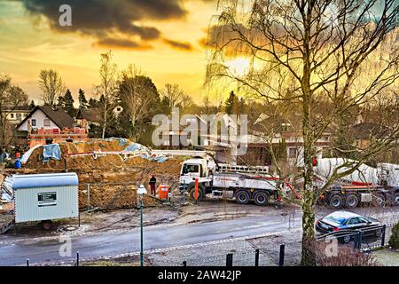 Berlin, Germany - March 9, 2018: Mobile concrete pump on a construction site at making the ground floor of a house in front of a wonderful sunset. Stock Photo