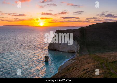 Lulworth, Dorset, UK.  6th February 2020. UK Weather.  A golden sunset at Bats Head near Lulworth in Dorset looking west towards Weymouth and the Isle of Portland viewed from the South West Coast Path on Swyre Head.  Picture Credit: Graham Hunt/Alamy Live News