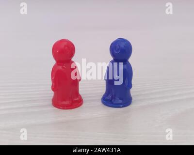 Conception  - work in a team, cooperation, adoptation, game figures or pawns in a business situation. Colored chips of tabletop game in the little me Stock Photo