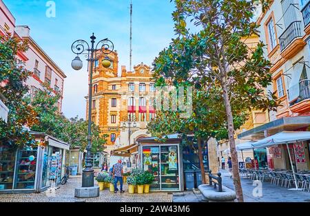 CADIZ, SPAIN - SEPTEMBER 20, 2019: The Plaza de Las Flores (Flower Square) with lush shady trees, small flower stalls, outdoor cafes, vintage streetli Stock Photo