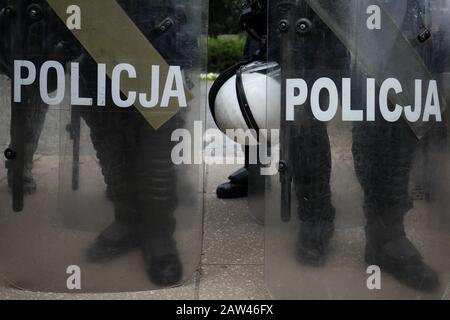 Polish policemen in action protect demonstrating people, white helmets, plastic covers Stock Photo