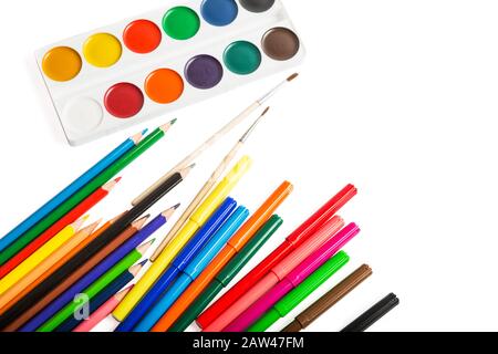 Set of accessories for drawing - colored pencils, markers, watercolor paints and brushes closeup isolated on white background Stock Photo