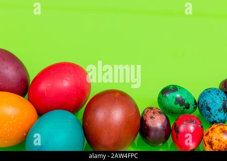 painted eggs of different colors on a green background, Easter decoration, Place for text Stock Photo