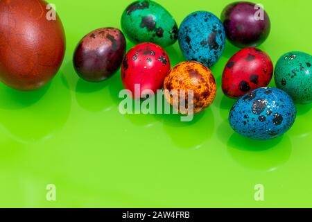 painted eggs of different colors on a green background, Easter decoration, Place for text Stock Photo