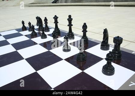 Texture, background. Background. BIG chess in the park. Large chess game on ground in the park . Big Chess Pieces Playing Game on the Floor . Giant Stock Photo