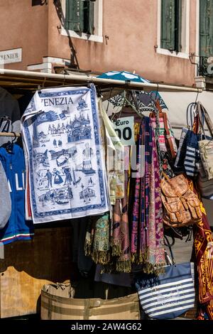 A market stall selling souvenirs to tourists including a tea towel