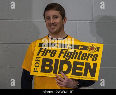 February 4, 2020, Concord, New Hampshire: A firefighter holding sign man in yellow Democrate candidate Joe Biden speaks at The International Brothers