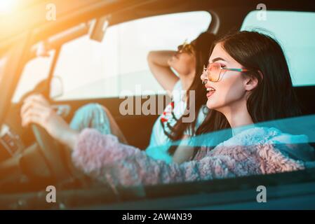 Two young modern woman having fun driving a car Stock Photo