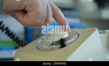 Businessman Working in Office Making a Phone Call from an Old Telephone Stock Photo