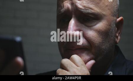 Worried Businessman Image in a Dark Room Using Smartphone Wireless Communication Reading Messages and Emails Stock Photo