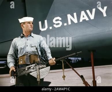 J.D. Estes, Portrait holding Machine Gun near U.S. Navy Fighter Plane, Naval Air Base, Corpus Christi, Texas, USA, photograph by Howard R. Hollem, U.S. Office of War Information, August 1942 Stock Photo