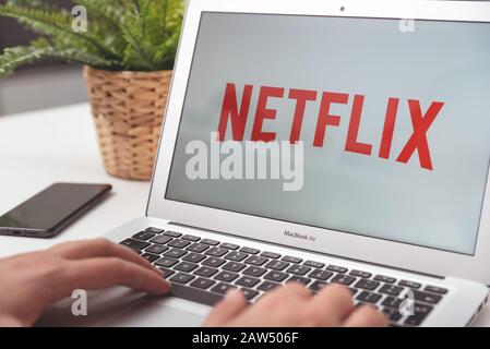 Wroclaw, Poland - OCT 23, 2019: Man with Netflix logo on screen. Netflix is most popular video streaming platform. Stock Photo