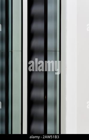 Architecture abstraction: modern escalator in motion, without people, frontal view. Movement and vertical lines pattern. Stock Photo