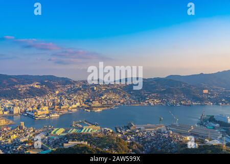 Nagasaki cityscape panorama view from Mt Inasa observation platform deck in sunny day sunset time with blue sky background, famous beauty scenic spot Stock Photo